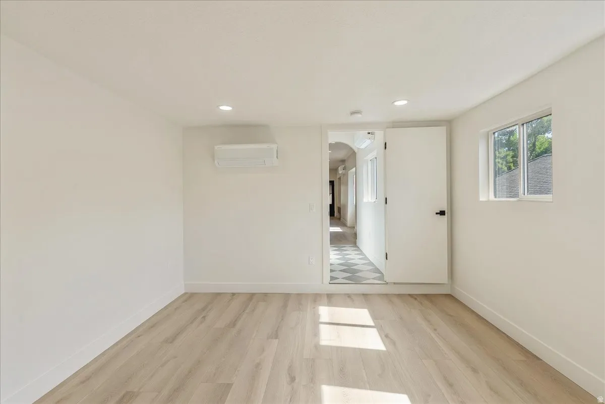 Room featuring light wood-finish flooring, white walls, and a recessed lighting fixture
