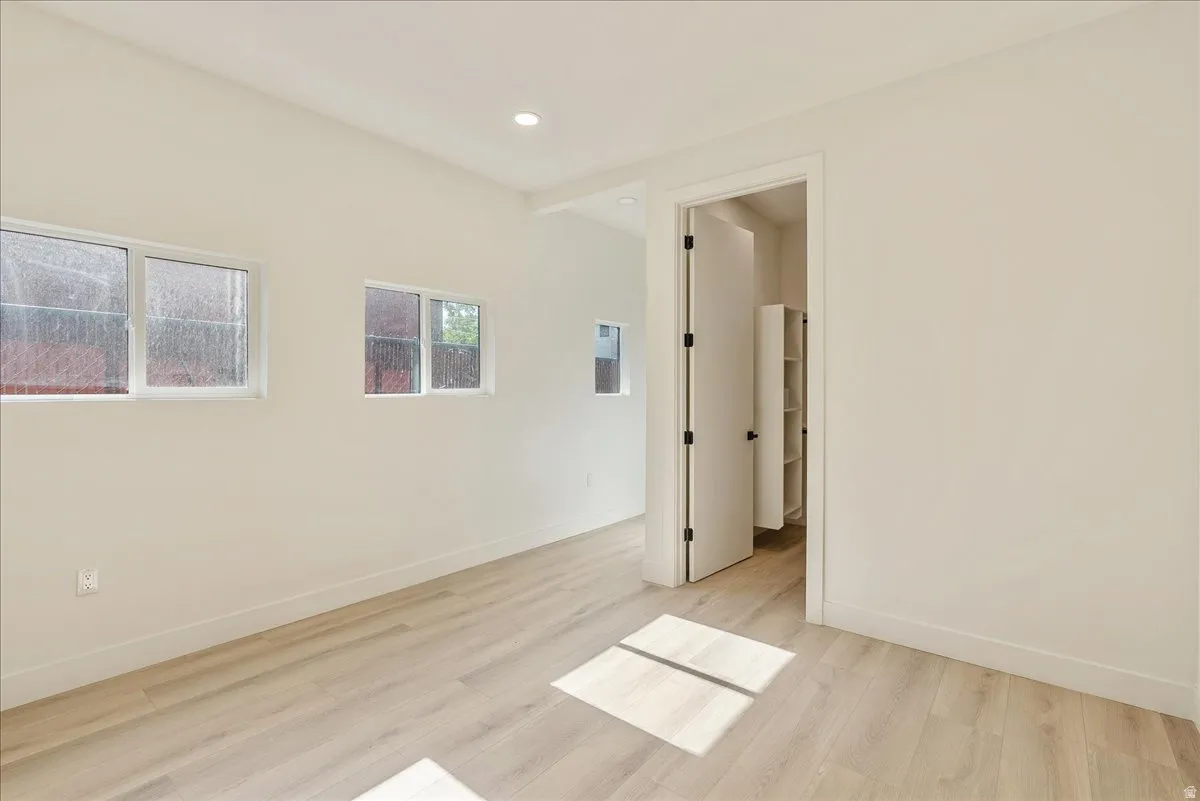 Bright interior space featuring light wood-finish flooring, recessed lighting, and multiple windows