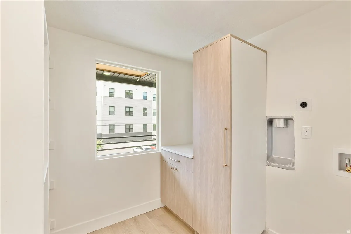 Modern utility room featuring light wood-finish flooring