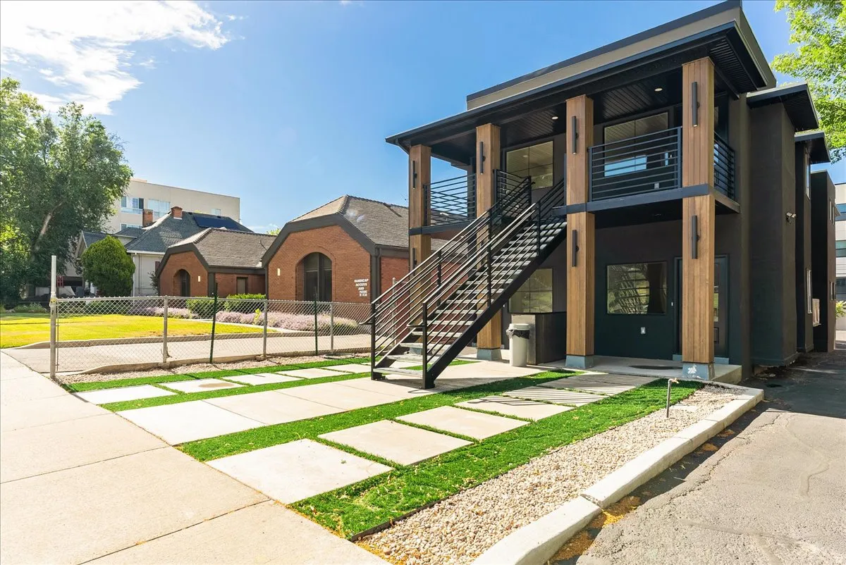 Modern multi-level exterior featuring a dark facade and warm wood-finish architectural elements