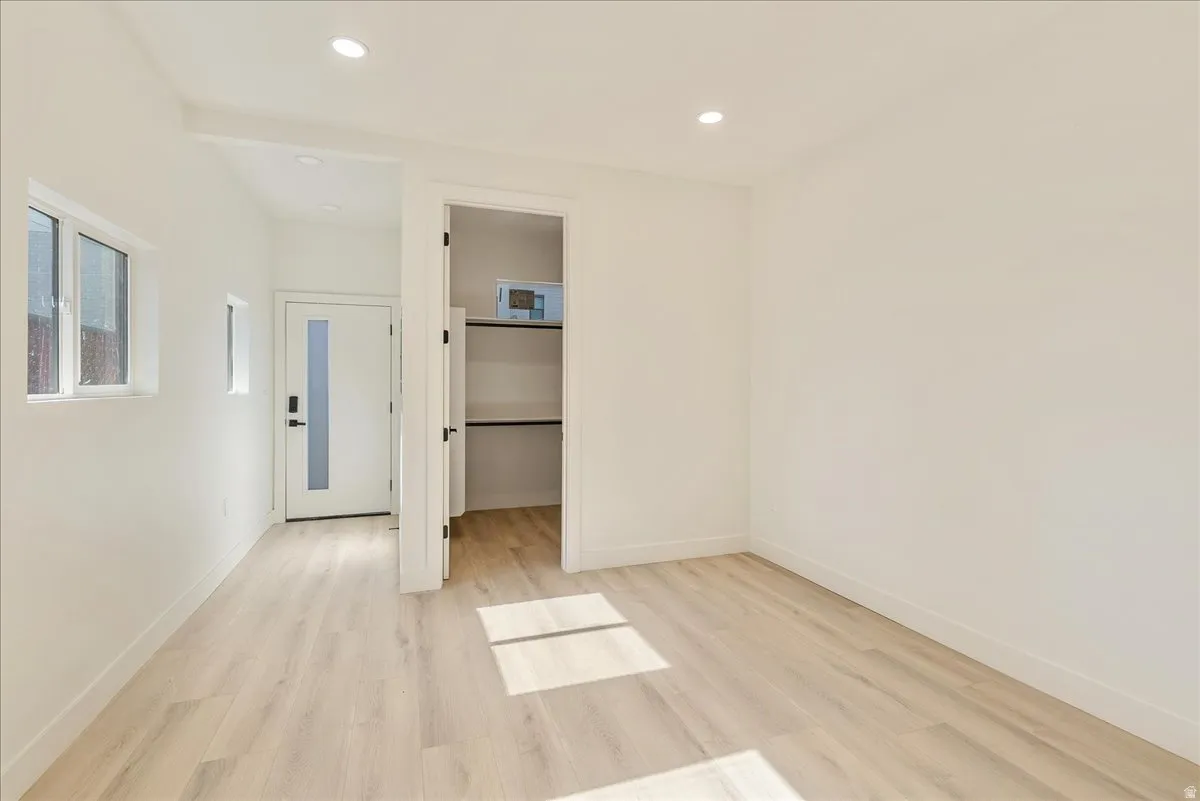 Light wood-finish flooring complements crisp white walls in this versatile room