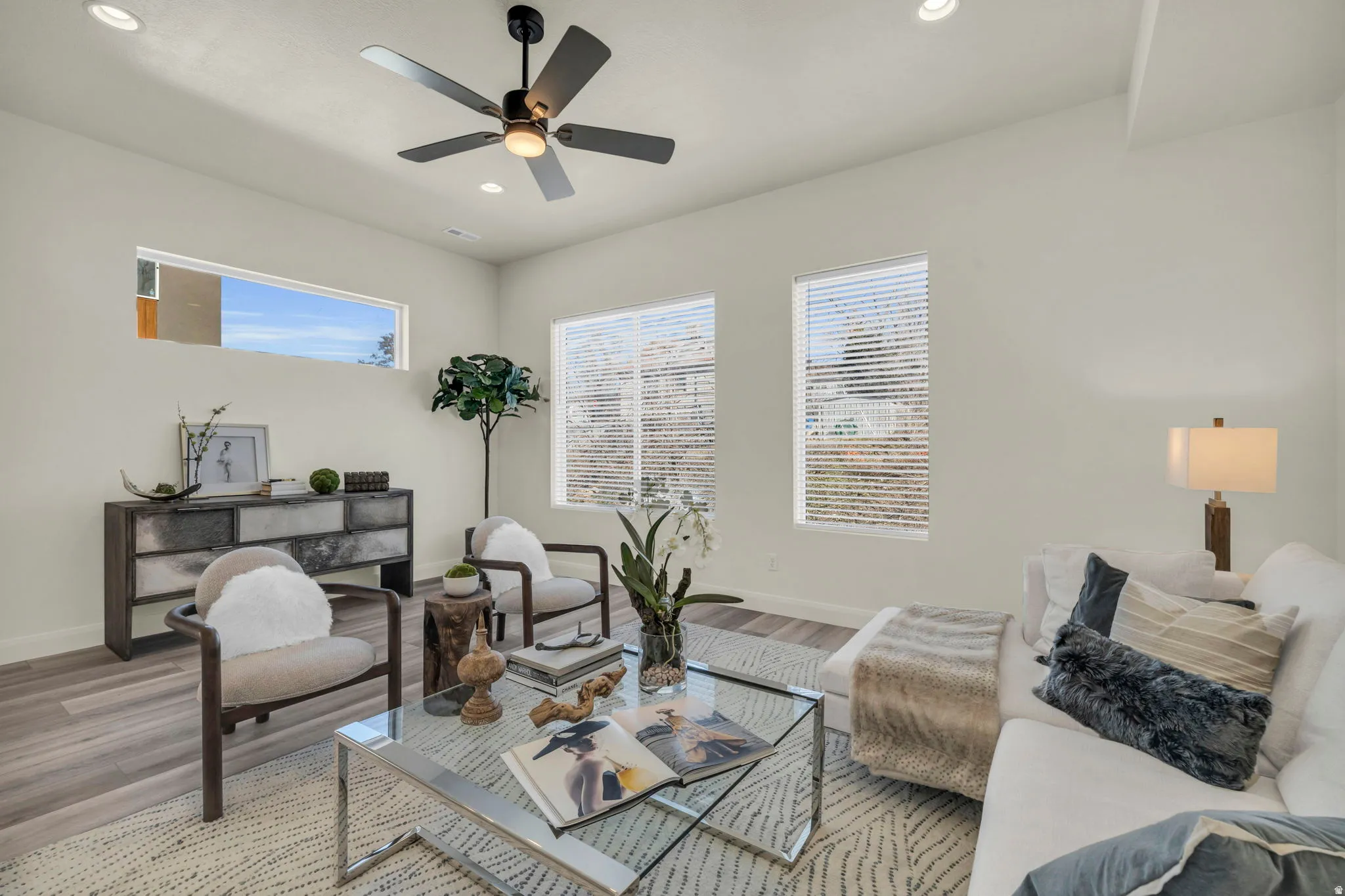 Living area featuring wood-finish flooring, recessed lighting, and a ceiling fan with integrated light