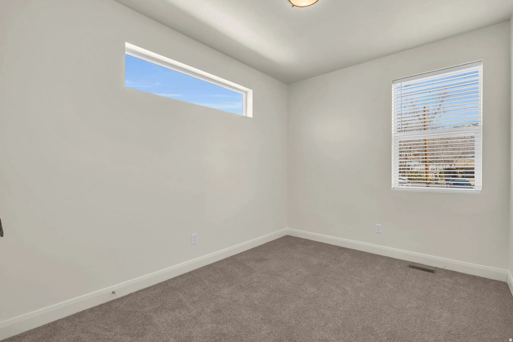 Carpeted interior room featuring light-toned walls
