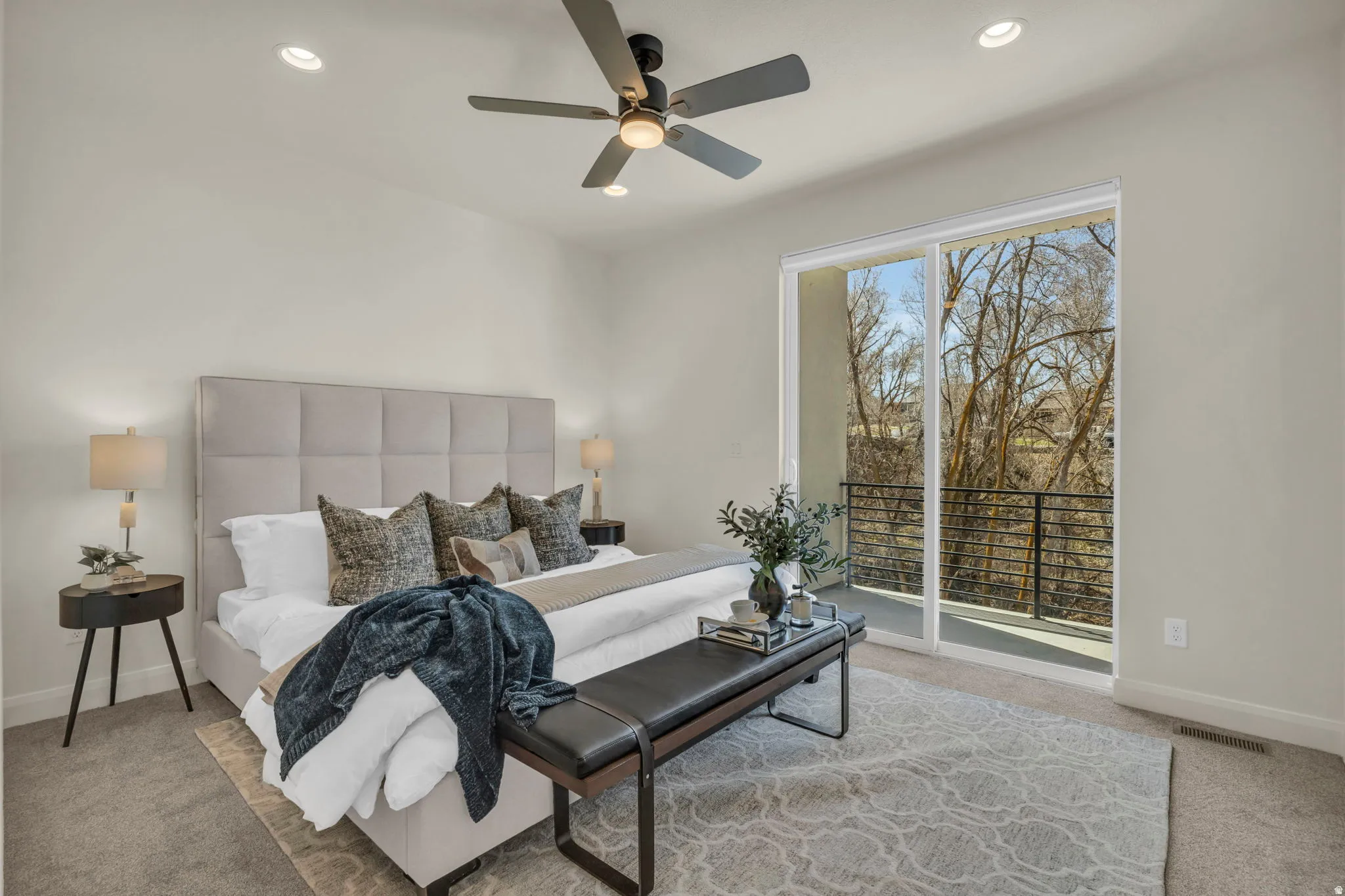 Sliding glass doors open to a private balcony with black metal railings