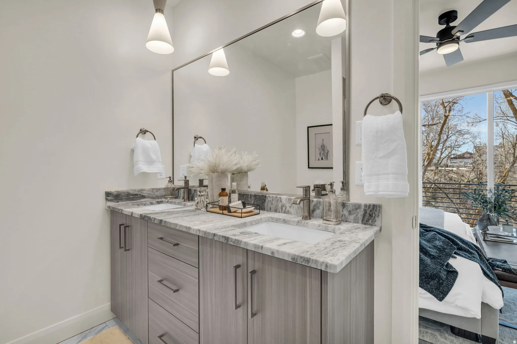 Double vanity with gray wood-finish cabinetry, integrated sinks, and polished chrome faucets