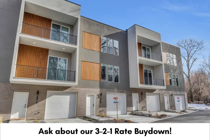 Contemporary facade with stucco and wood-finish paneling, private balconies with metal railings, individual garage access, and brick accents