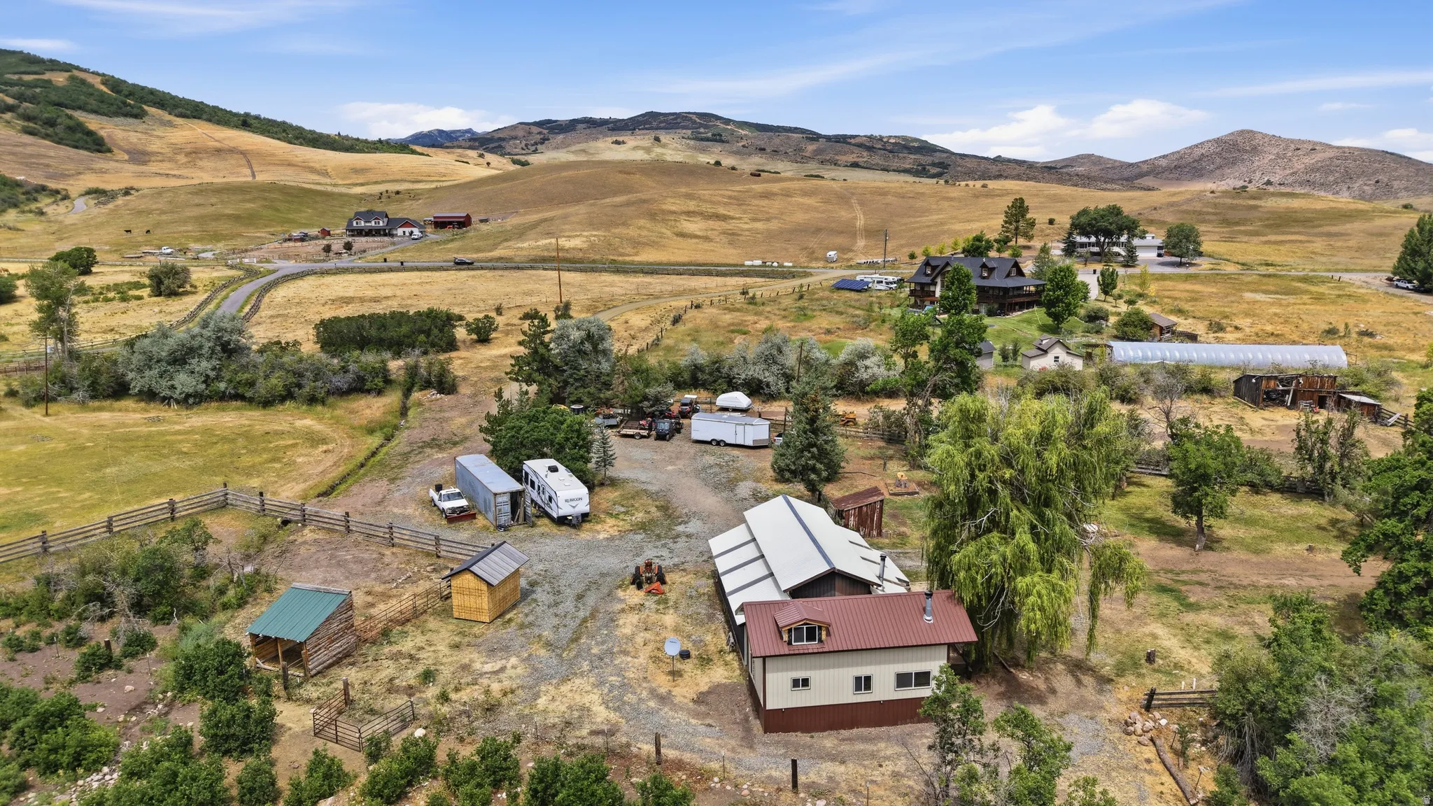Expansive property featuring a mix of natural landscaping and cleared areas, surrounded by rolling hills