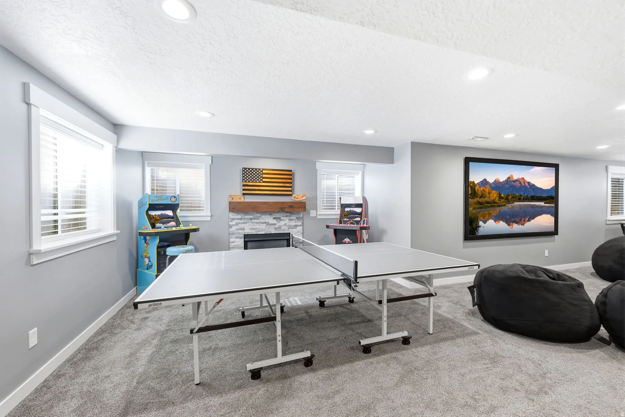 Spacious room featuring light gray walls, recessed lighting, and soft gray carpeting