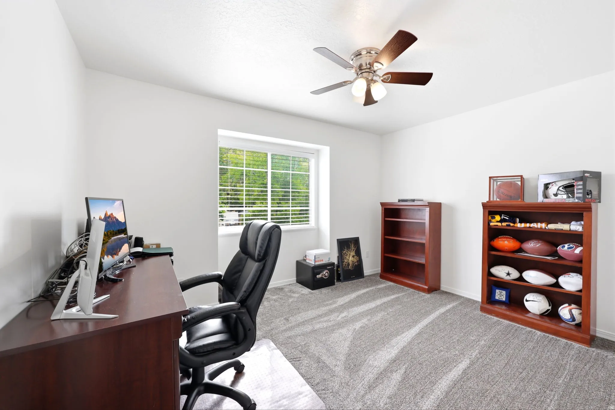 Room featuring light gray patterned carpeting, a large window with white blinds, a ceiling fan with integrated lighting, and white walls