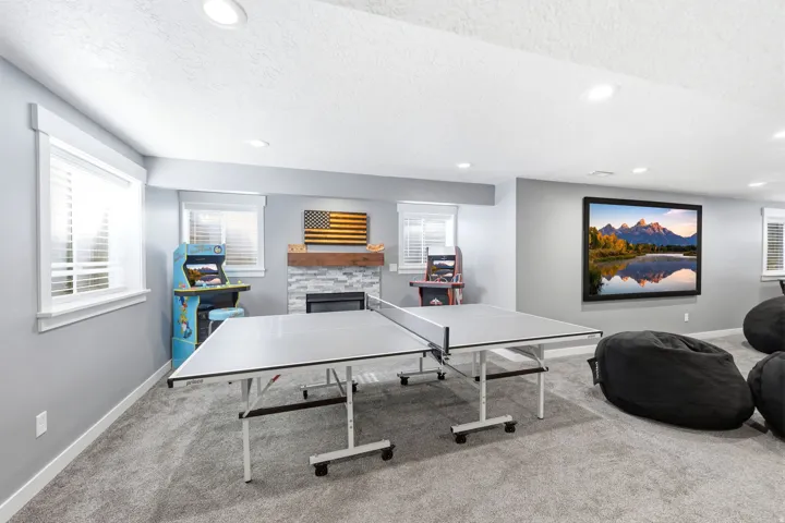 Spacious room featuring light gray walls, recessed lighting, and soft gray carpeting