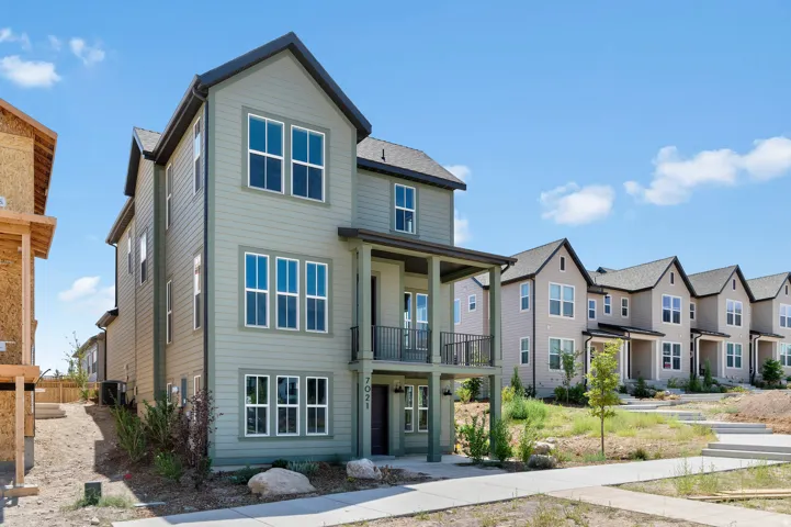 Three-story exterior with horizontal siding and a covered entry
