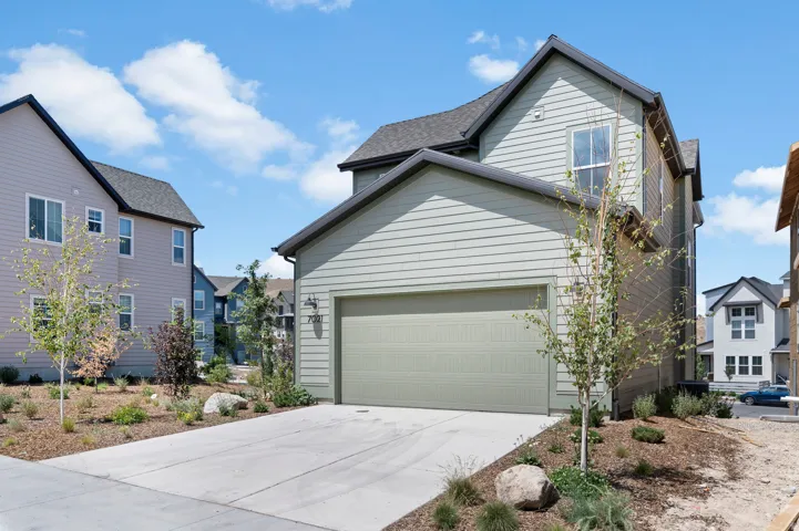 Modern home exterior featuring light green horizontal siding and a matching garage door
