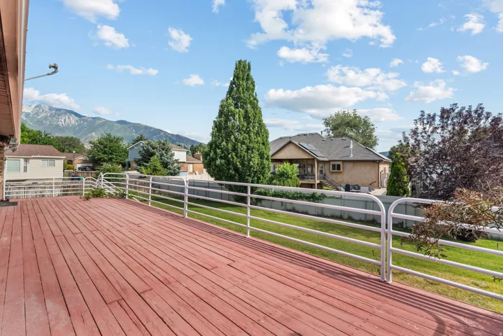Spacious outdoor deck with reddish-brown wood planks and white metal railings