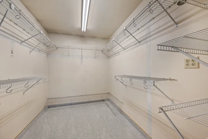 Walk-in closet featuring extensive wire shelving, hanging rods, and light-colored walls