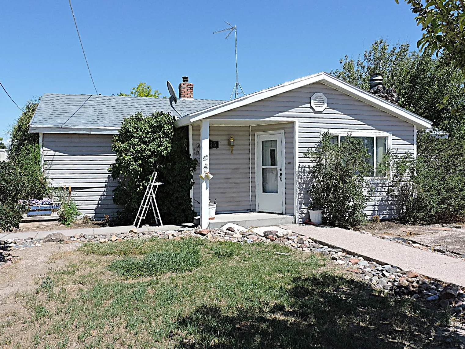 Ranch-style residence featuring horizontal siding, a covered entry porch, and a pitched shingle roof