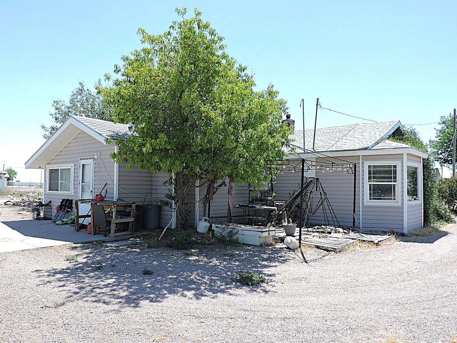 Single-story property with light gray horizontal siding and a gray shingle roof