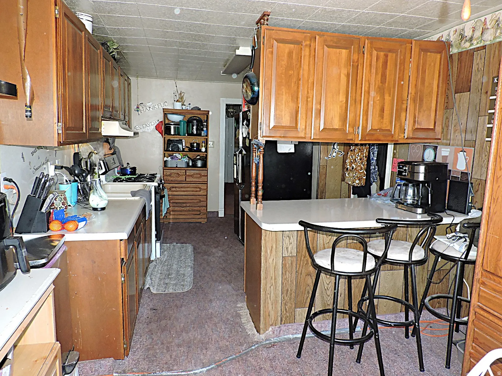 Kitchen featuring wood-finish cabinetry, solid surface countertops, and a peninsula with bar seating