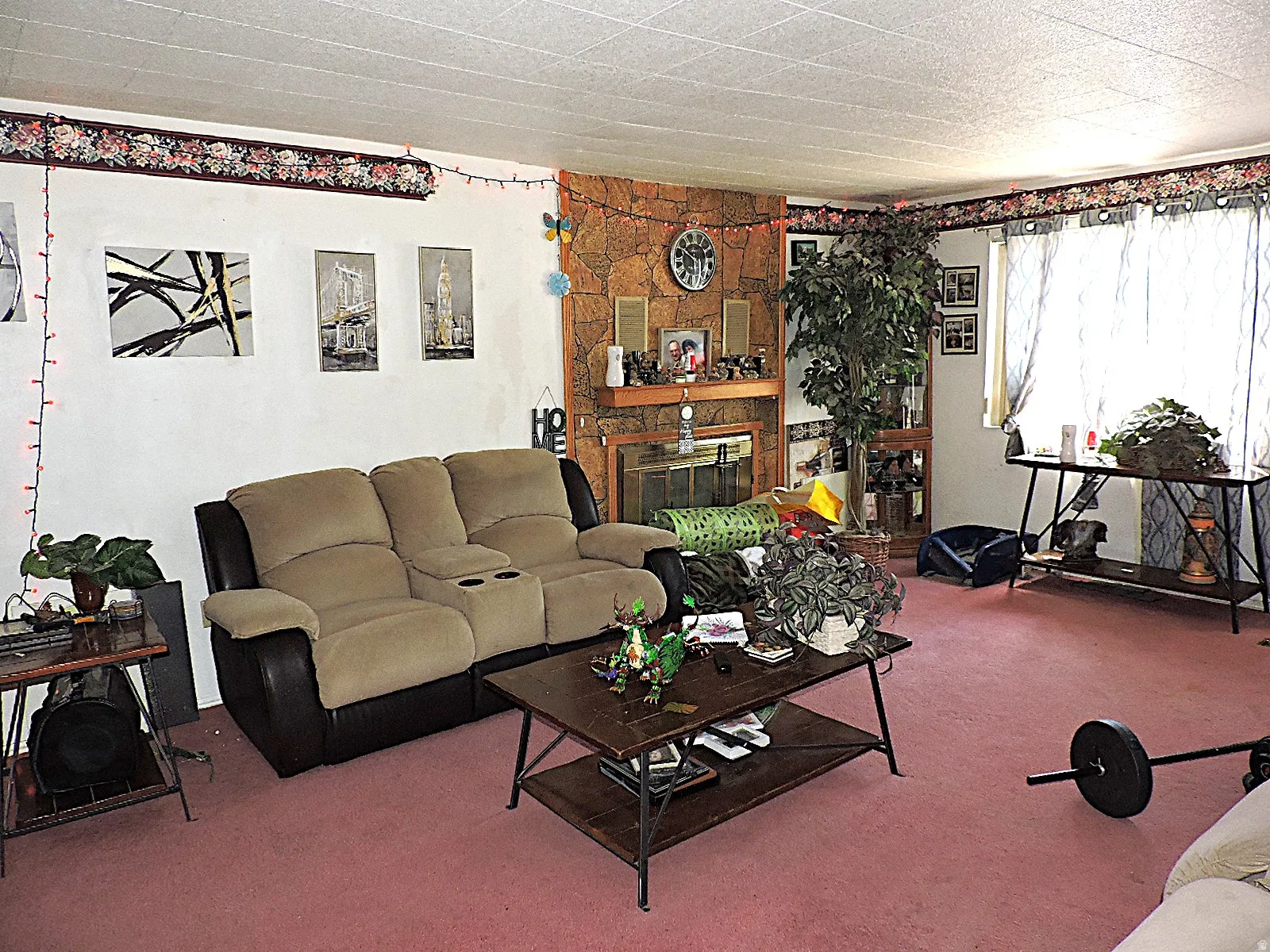 Living room featuring a prominent fireplace with a hearth, a contrasting white wall
