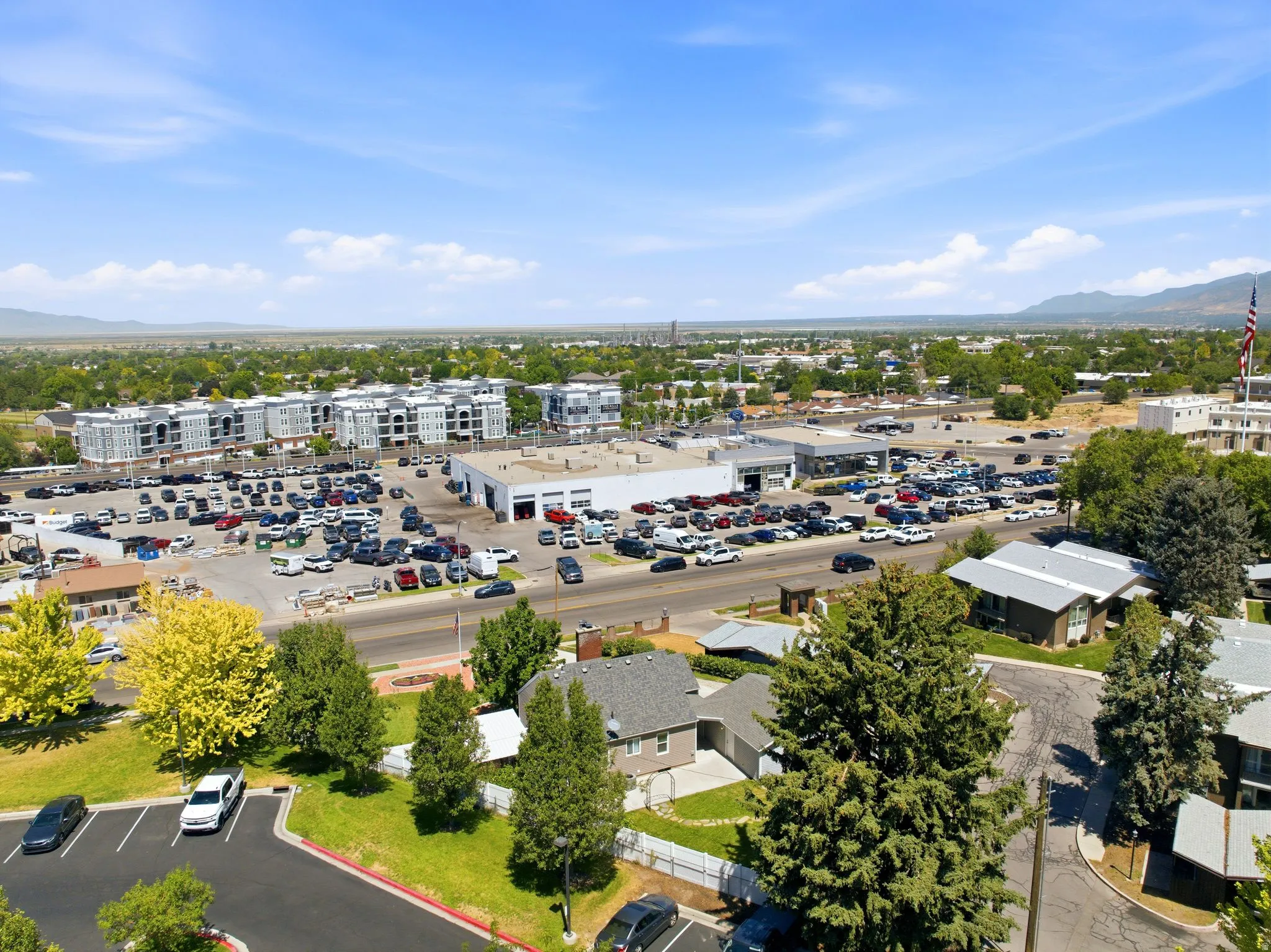 Expansive aerial view showcasing a commercial district with multiple buildings and extensive parking areas