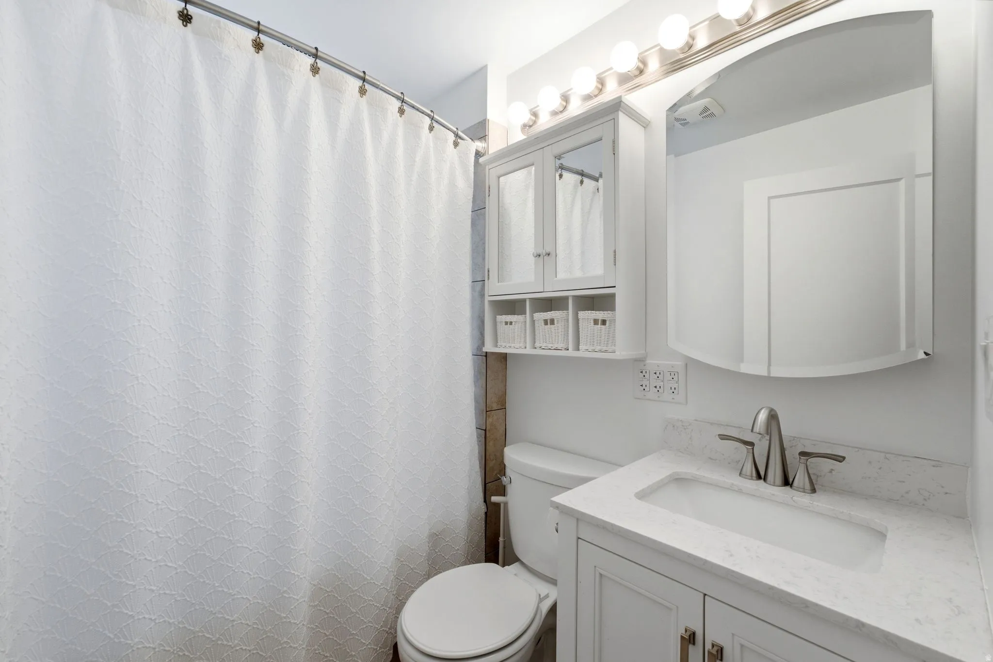 Bathroom featuring a white vanity with a light-colored countertop, an undermount sink, and brushed nickel fixtures