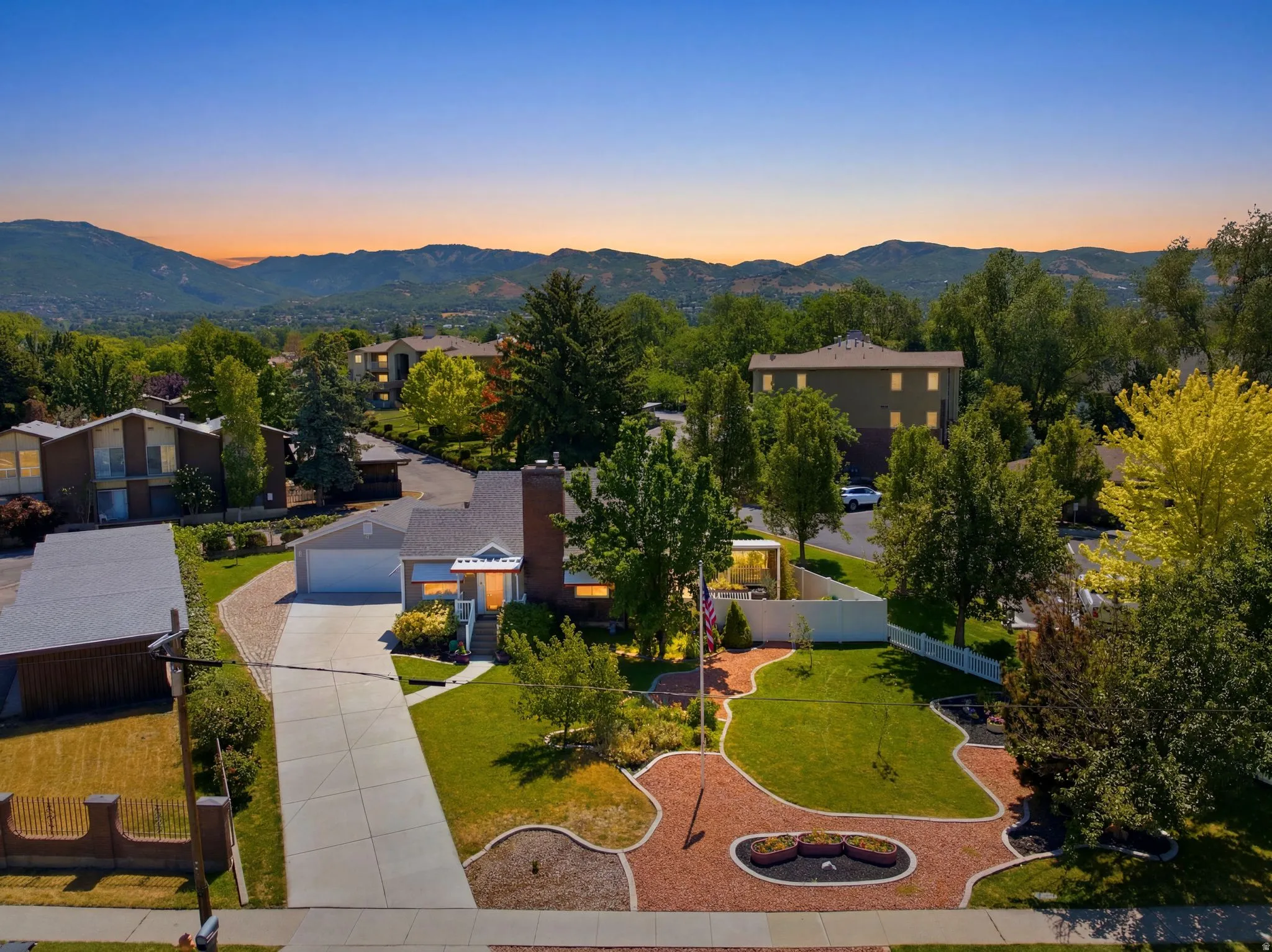Two-story residence featuring a prominent brick chimney, an attached garage, and a long concrete driveway