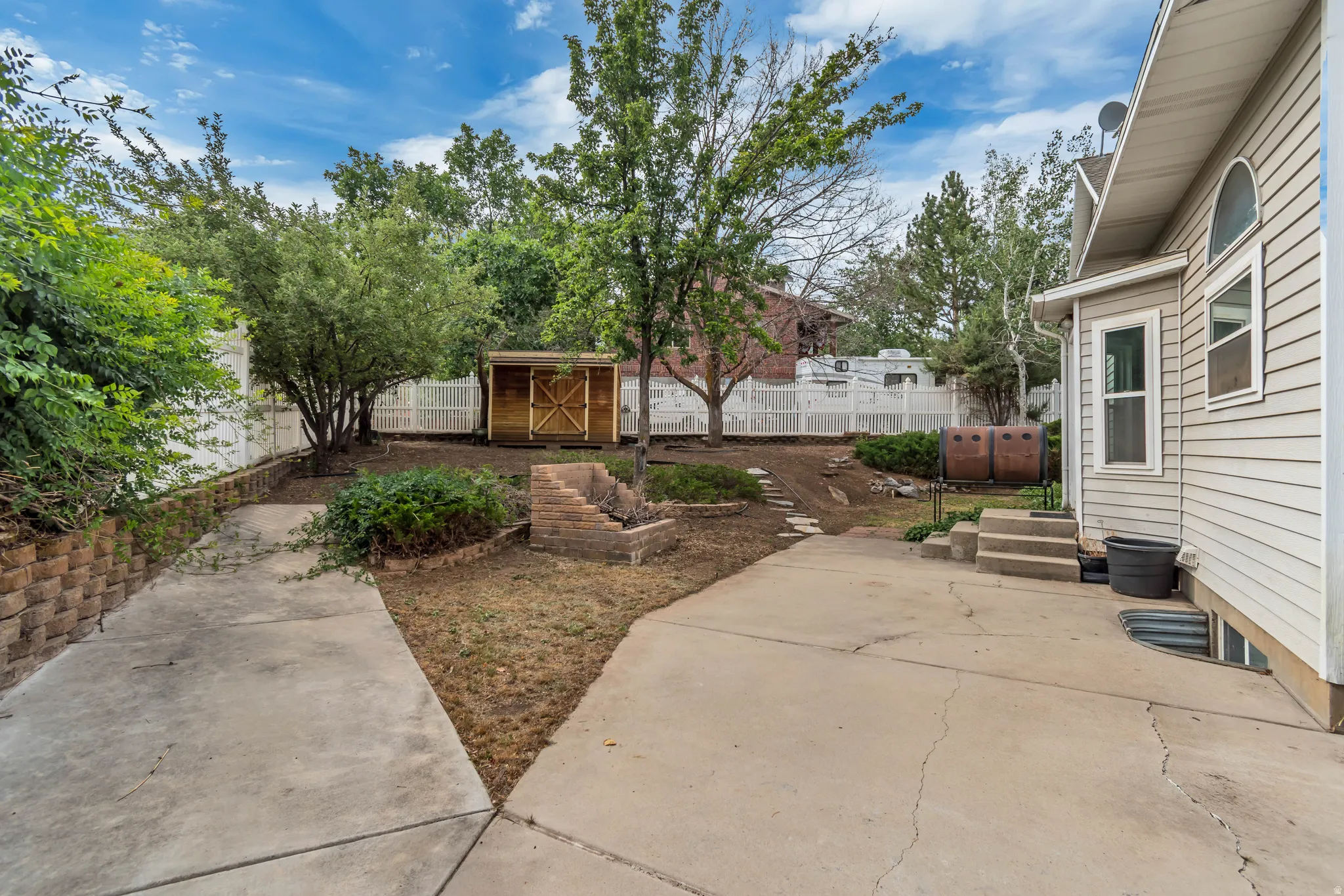 Expansive concrete patio area with multi-level landscaping