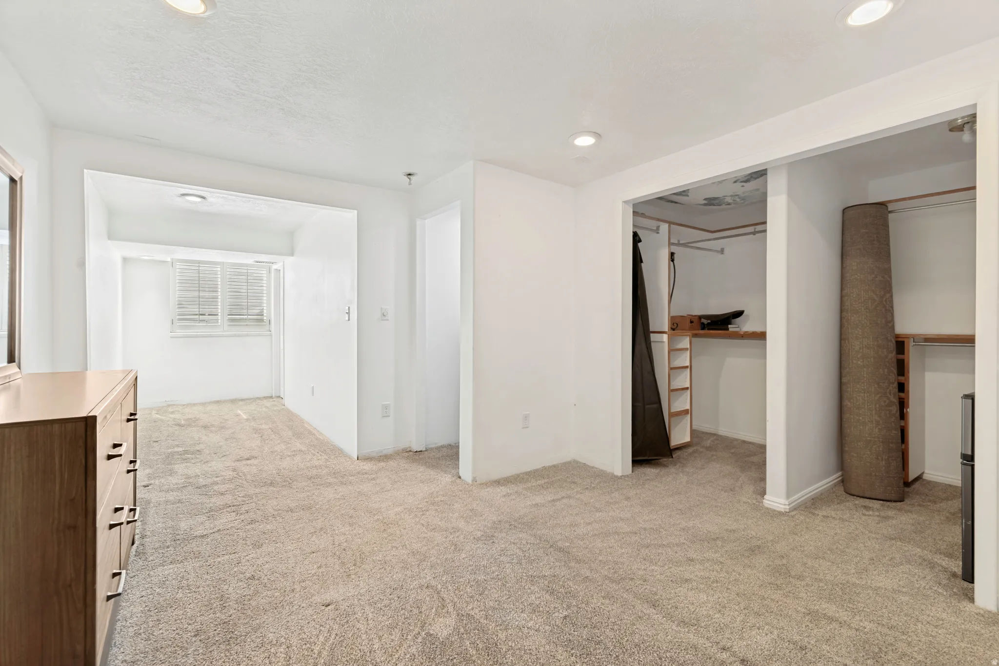 Neutral-toned carpet flooring extends throughout this interior space, illuminated by recessed ceiling lighting