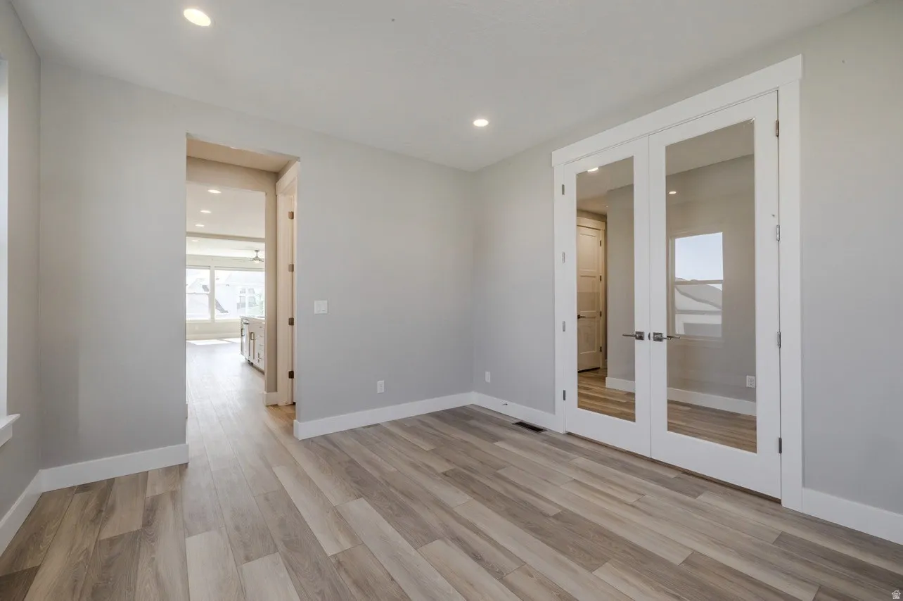 Interior room featuring light wood-finish flooring, recessed lighting, and white baseboards