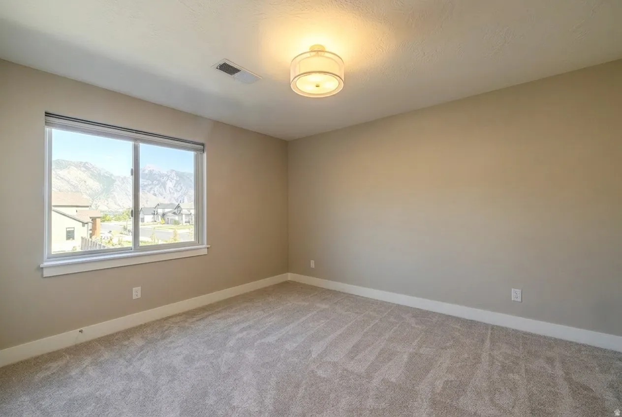 Bedroom featuring a large window, neutral carpeting, light beige wall paint, white trim, and a ceiling-mounted drum light fixture
