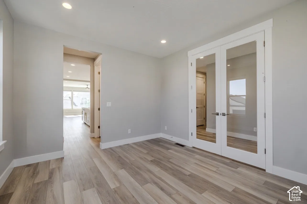 Interior room featuring light wood-finish flooring, recessed lighting, and white baseboards