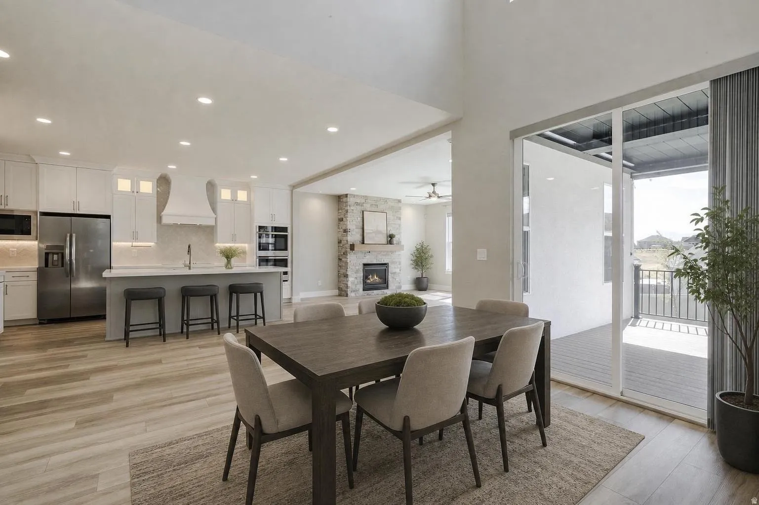 Dining area with wood-finish flooring, a contemporary dining table, and direct access to an outdoor patio via large sliding glass doors