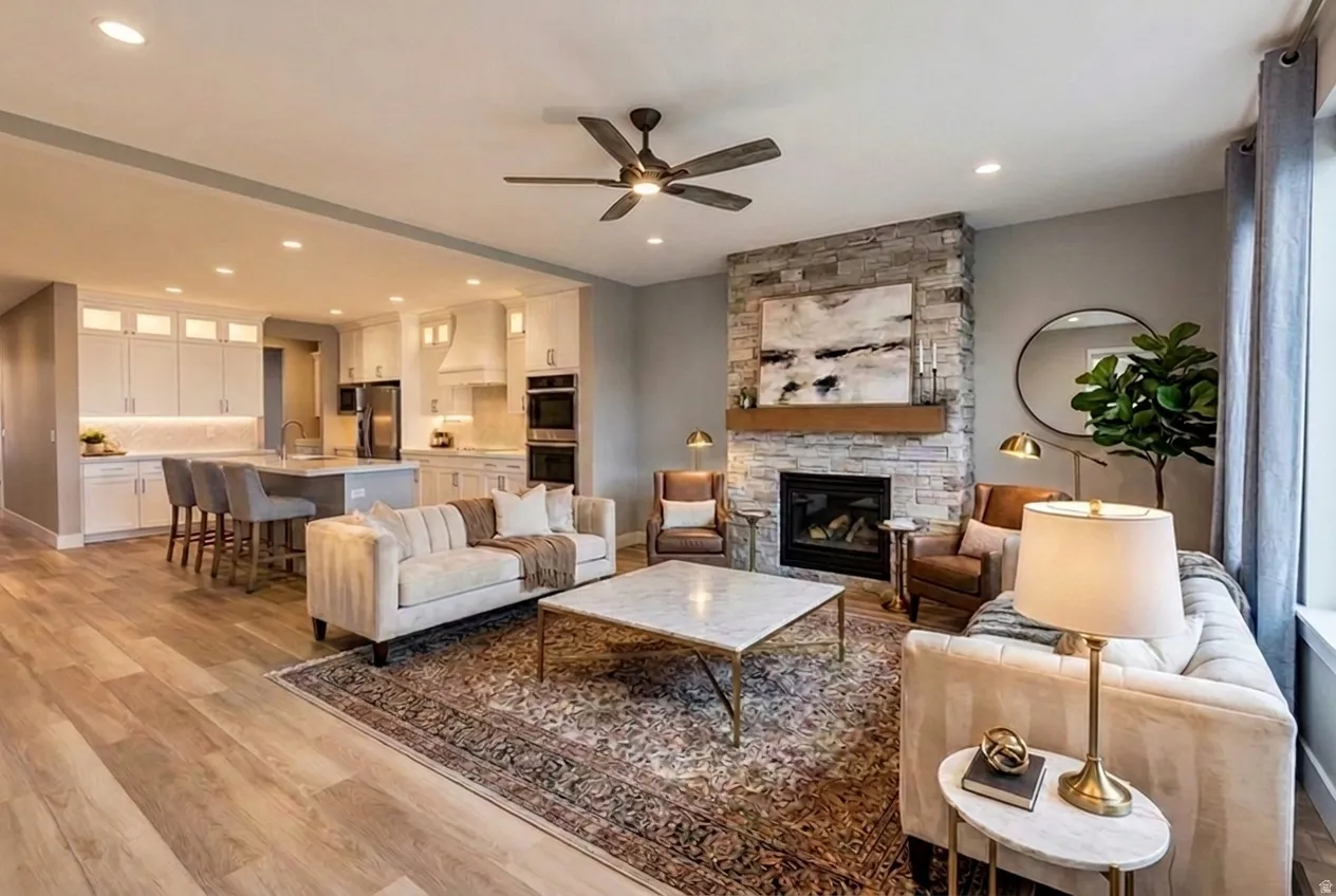 Virtual Staging. Open-concept living space featuring wood-finish flooring and a stone-clad fireplace with a wood mantle