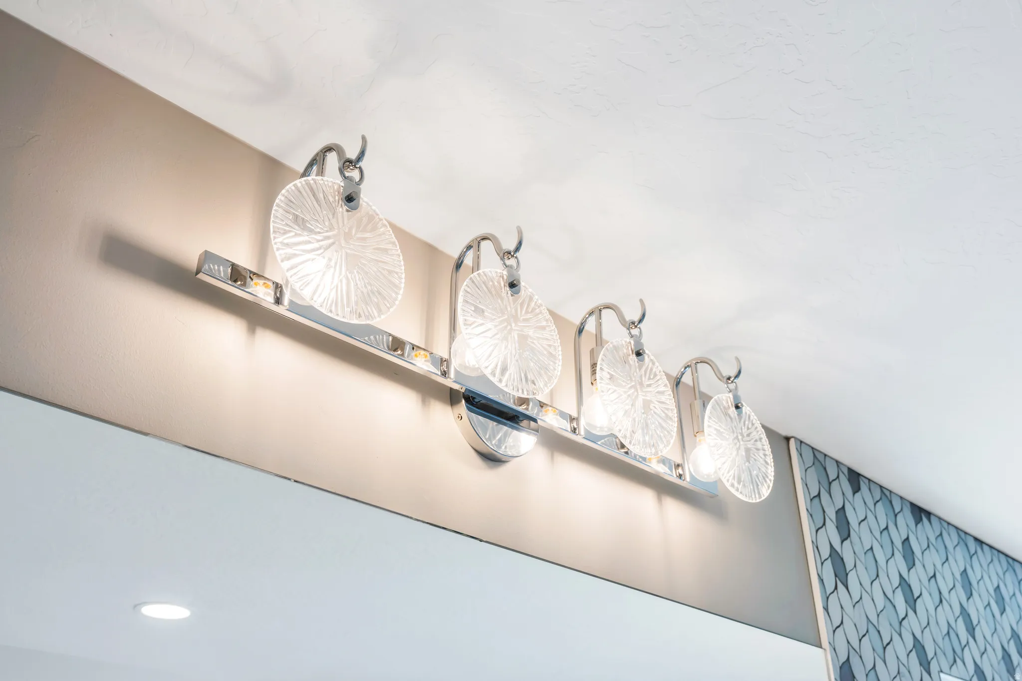 Primary bathroom with a polished chrome vanity light fixture with five textured glass shades