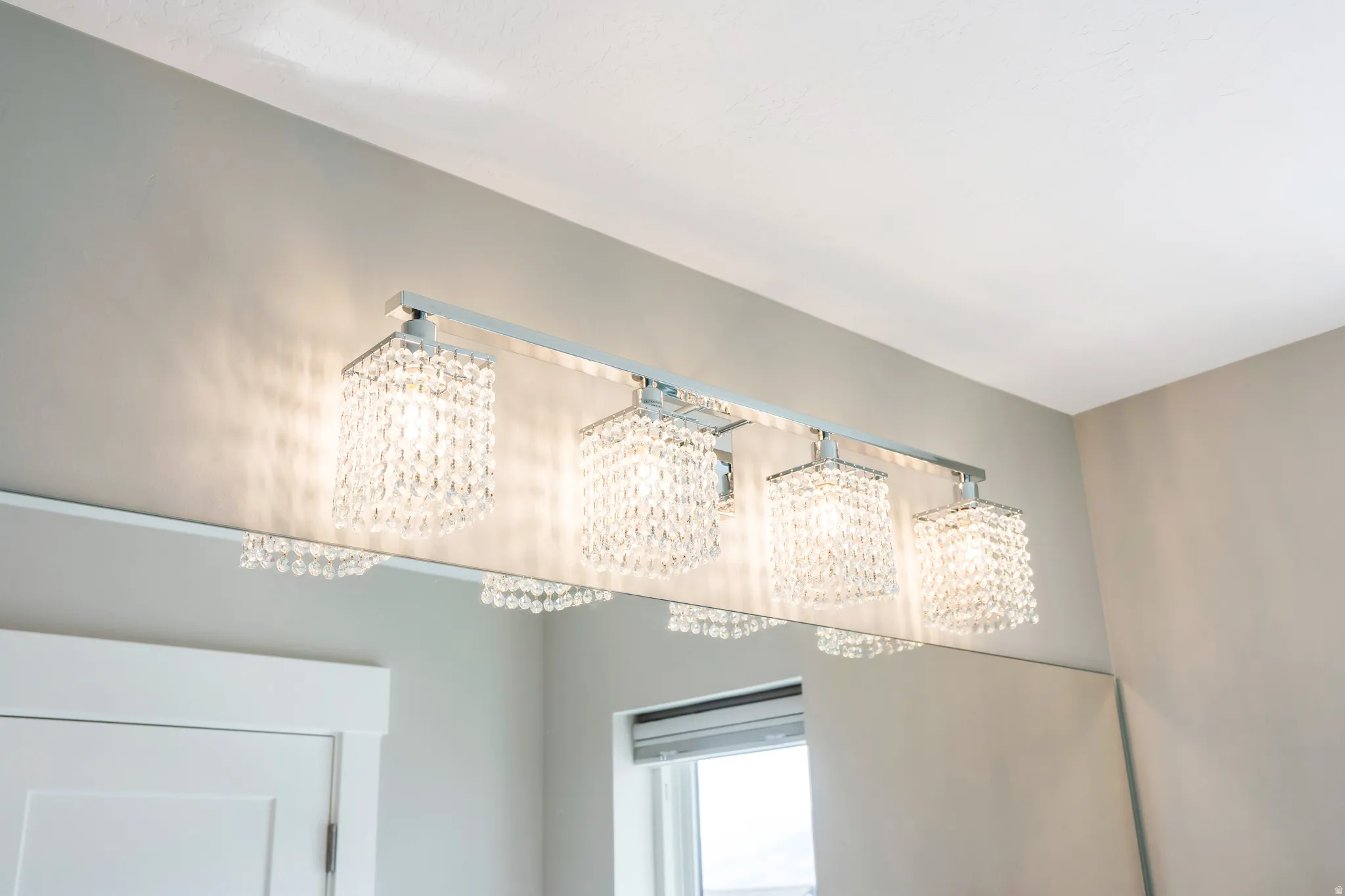 Four-light vanity fixture featuring crystal-beaded shades and a polished chrome finish