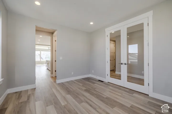 Interior room featuring light wood-finish flooring, recessed lighting, and white baseboards