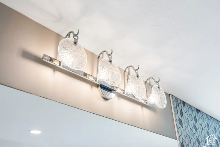 Primary bathroom with a polished chrome vanity light fixture with five textured glass shades