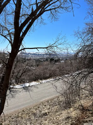 Sloping terrain with a paved road and a distant mountain range
