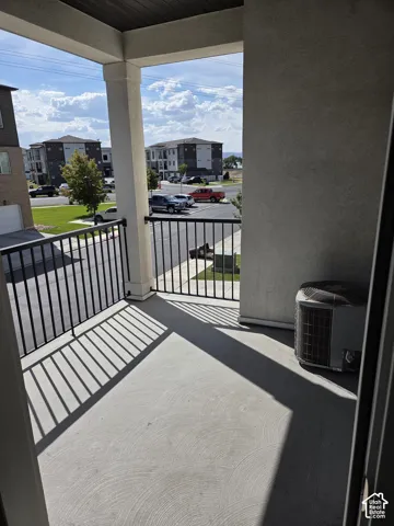 Private balcony featuring a concrete surface, black metal railing, and stucco exterior walls