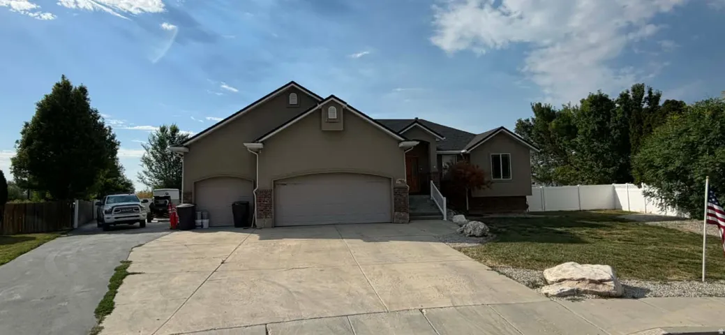 Exterior featuring stucco siding, stone accents, and a dark shingle roof
