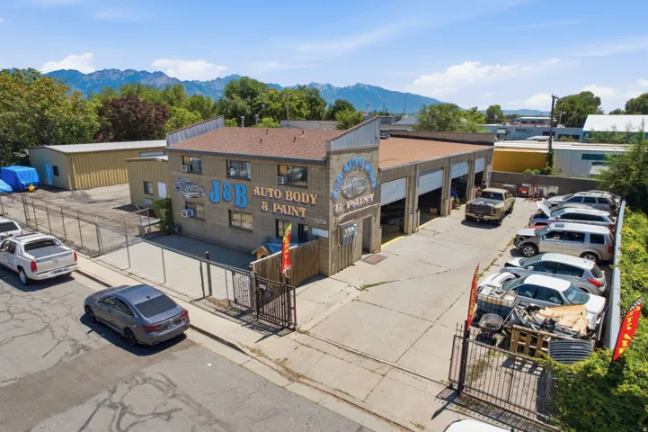 Commercial property featuring a multi-bay auto body and paint shop with overhead doors and a brick facade
