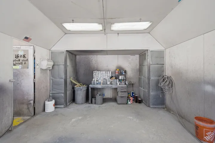 Dedicated workspace featuring an overhead ventilation system, concrete flooring, and industrial-style lighting