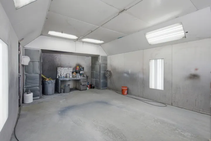 Dedicated workspace featuring a concrete floor, built-in shelving, and integrated overhead lighting