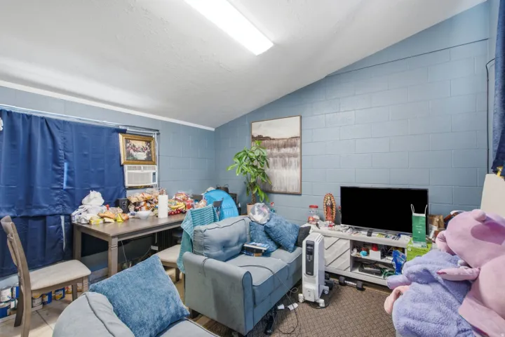 Living area featuring a textured accent wall, angled ceiling, and recessed lighting