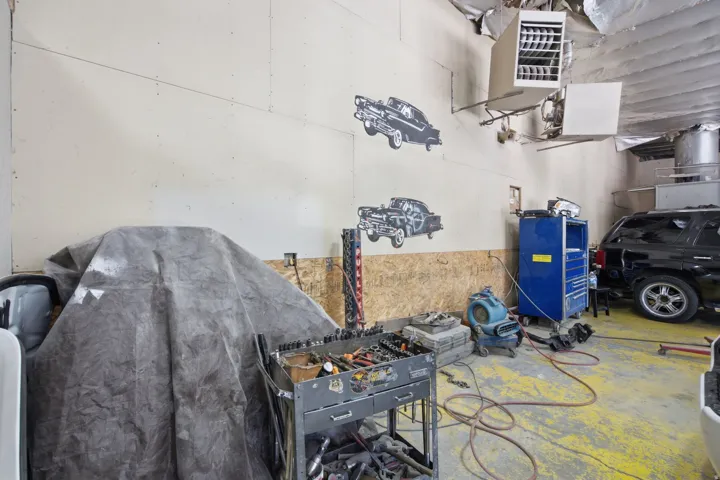 Utility space featuring concrete flooring with yellow paint, drywall walls, and exposed ceiling ductwork