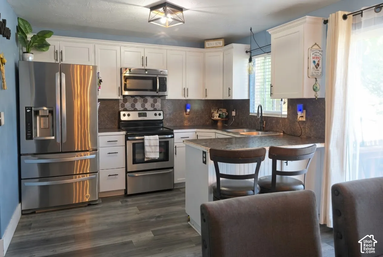 Kitchen featuring white cabinetry, stainless steel appliances