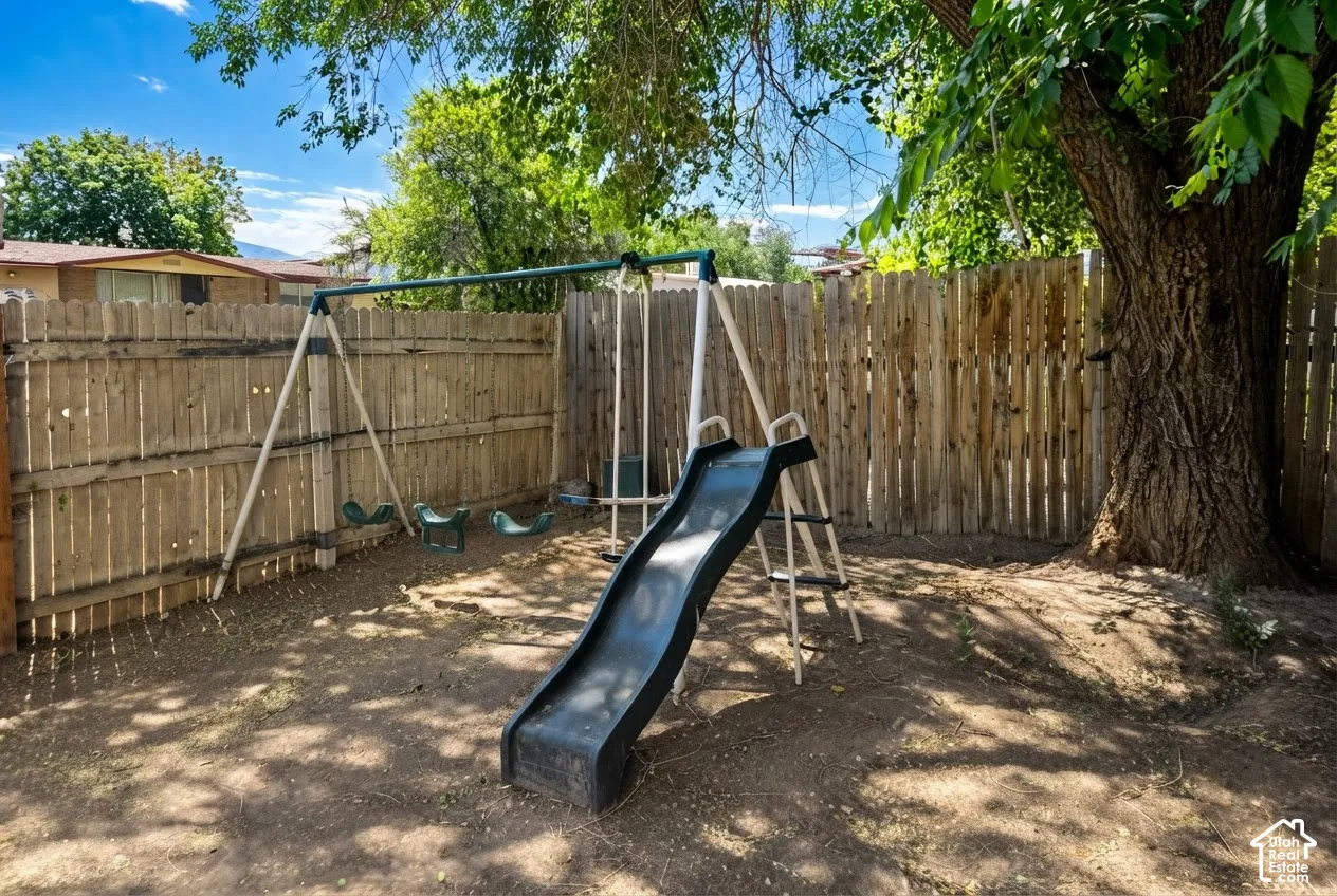 Private backyard area featuring a wood plank fence and mature shade trees