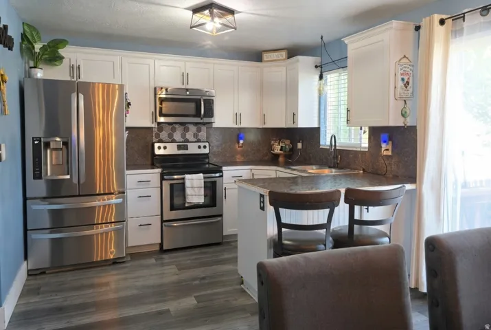 Kitchen featuring white cabinetry, stainless steel appliances