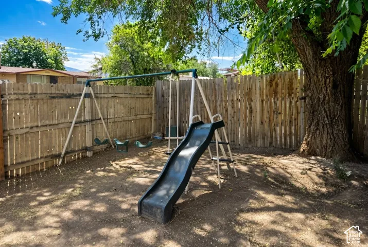 Private backyard area featuring a wood plank fence and mature shade trees