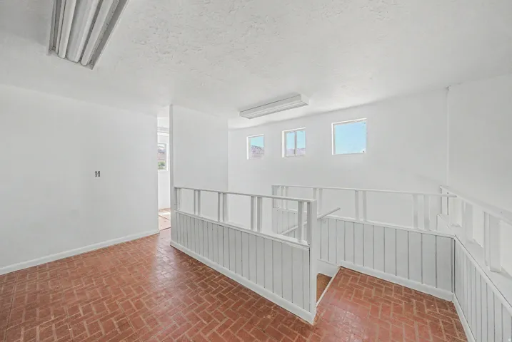 Upper level with brick flooring and white painted walls