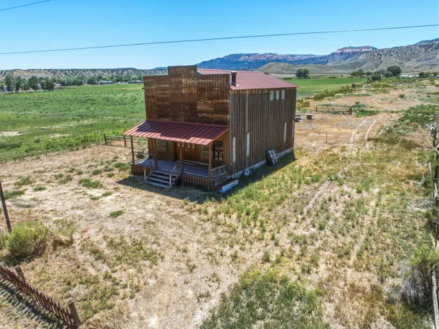 Barn-style structure featuring a metal roof, wood siding, and an elevated front porch